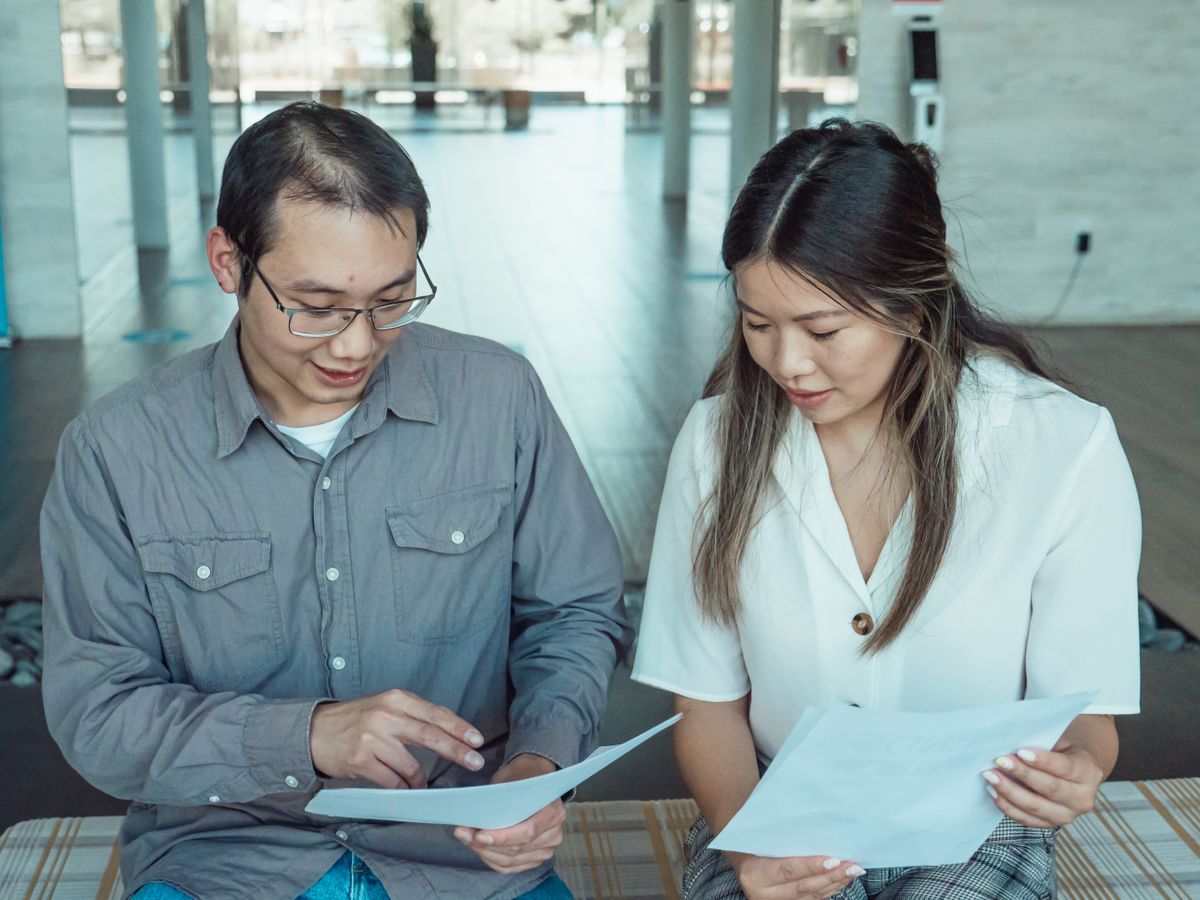 Two coworkers reviewing documents in a modern office