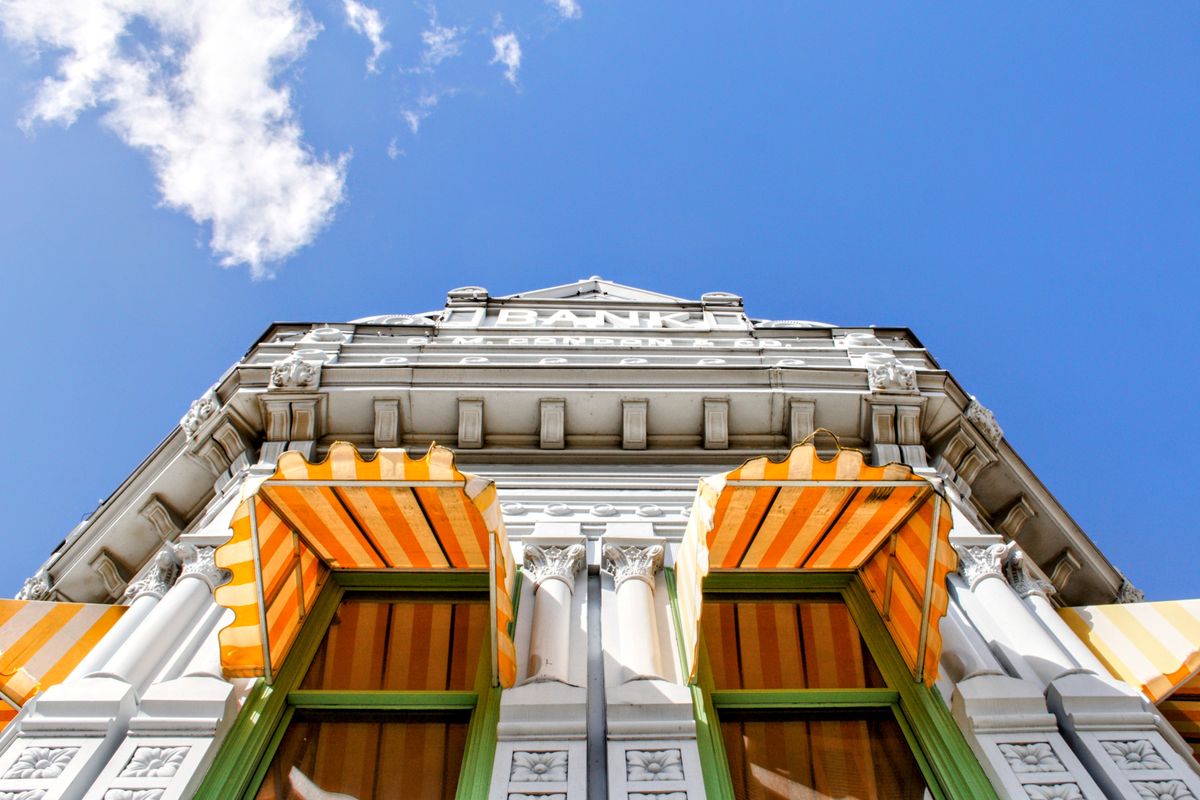 Historic bank building facade with striped awnings