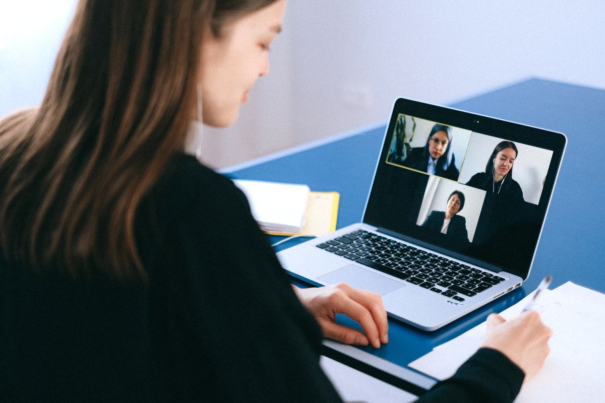 Woman on a video conference at home taking notes