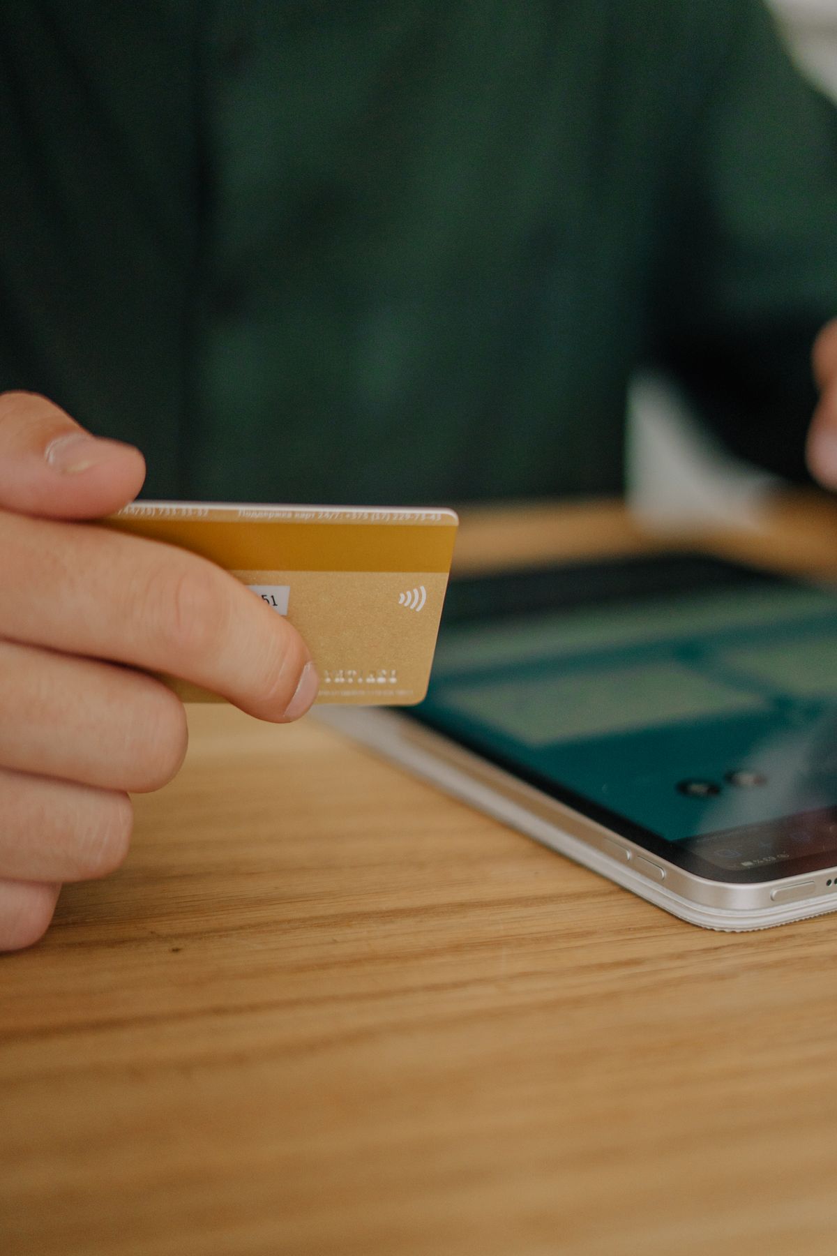 Person making a contactless payment with a credit card on a tablet