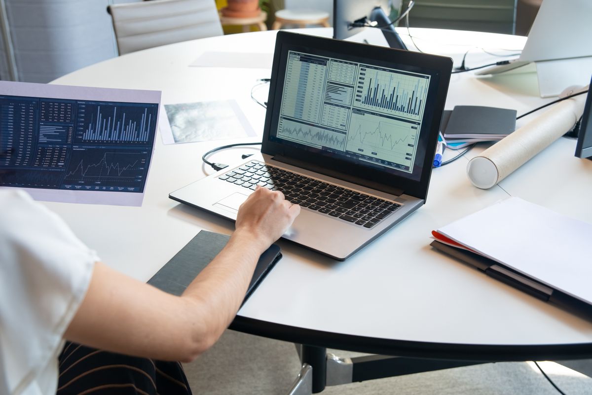 Business person evaluating financial charts on a laptop