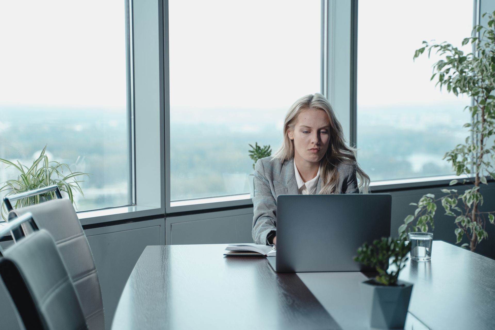 Professional woman carefully reviewing a job posting on her laptop.