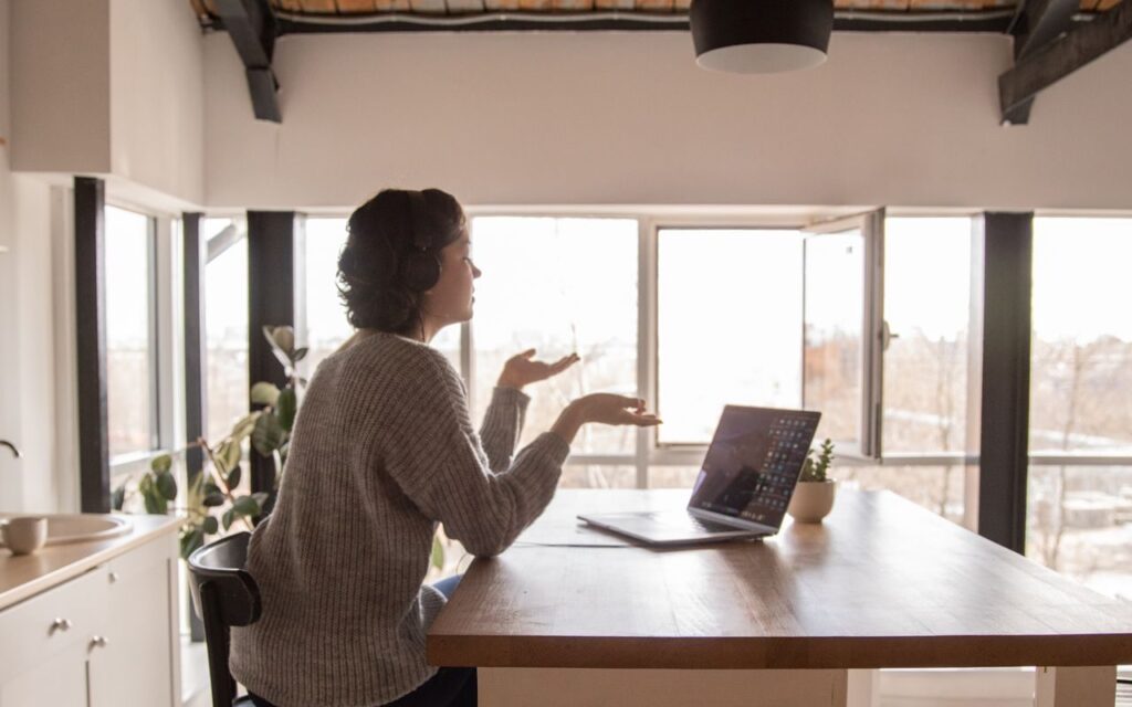 A freelancer on a video call with a client from her home workspace